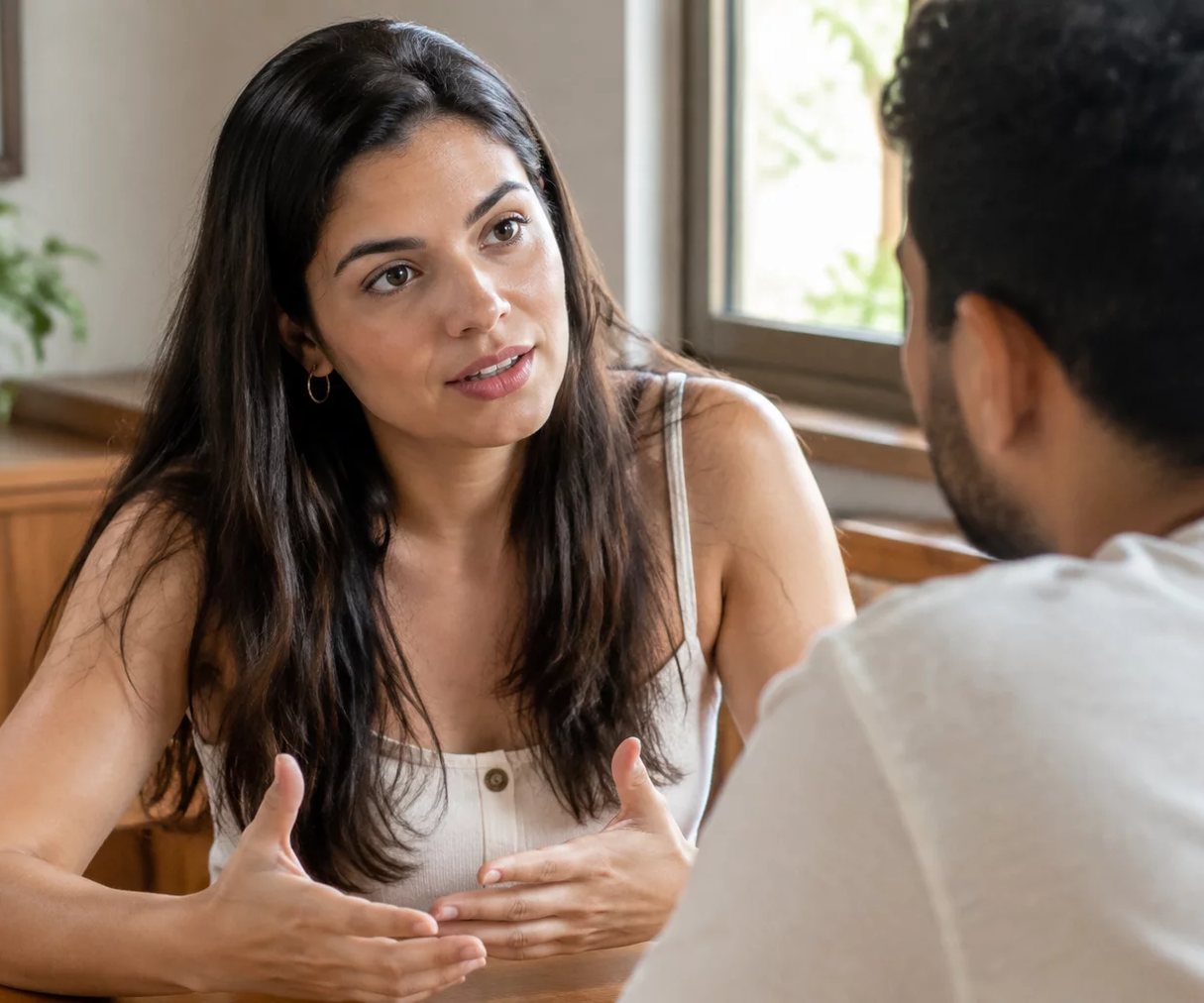 Duas pessoas frente a frente na mesa: uma sustenta a fala, a outra anota o que ouviu